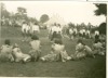Image 2 of 8 : 1949 Speech Day - country dancing on the tennis courts. Joan Parsons is sitting on the grass, centre of picture, and Ruth Parsons is standing centre right.