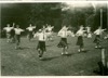 Image 3 of 8 : 1949 Speech Day - country dancing on the tennis court on a very hot day. Ruth Parsons is at the back, on the left.