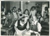 Image 7 of 8 : 1949 - cookery class - Gaby Tuke-Scott and either Mary or Ruth Tudor-Jones (the other twin is at the back tasting something with "Titch"). Ann Widdows is in front of them (with the baking tray). Judith Clarke is in the centre of the picture looking straight at the camera. Shirley Cowing is behind her, to the right, and Anne Wilson beside her (behind Gaby). Lynne Clark is at the back on the right.